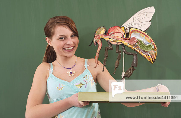 Deutschland  Emmering  Mädchen (12-13) mit Fliegenmodell  lächelnd  Portrait