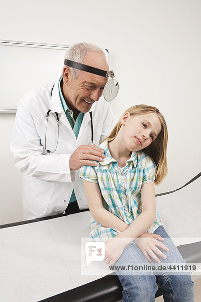 Doctor examining girl (8-9) in clinic