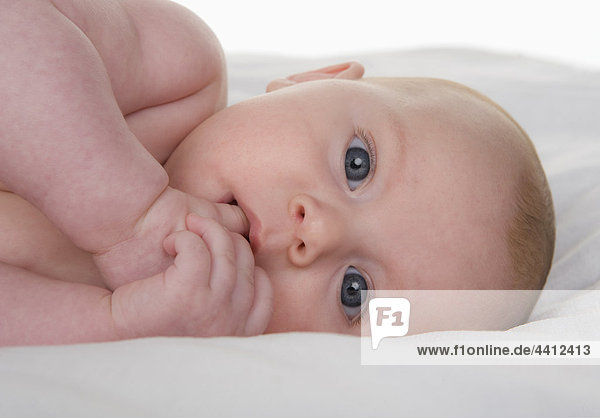 Baby Mädchen (2-5 Monate) Finger im Mund  Portrait