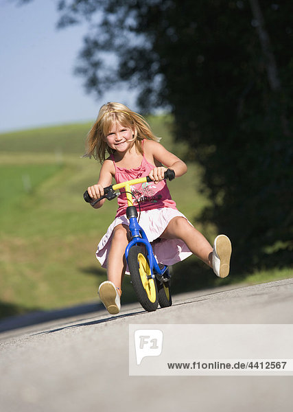 Austria  Mondsee  Girl (4-5) riding bicycle  smiling  portrait