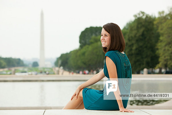 Girl von Widerspiegelnder Teich mit Washington Monument in Entfernung
