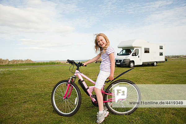 Girl with a bicycle near caravan