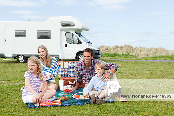 Familie beim Picknick mit dem Wohnwagen
