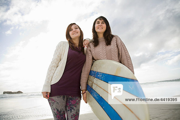 Zwei Mädchen mit Surfboard  Portrait