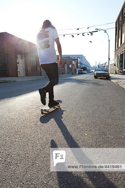 Skateboarder auf urbaner Straße im Sonnenlicht