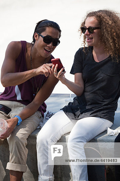 Skateboarder Freunde mit smartphone