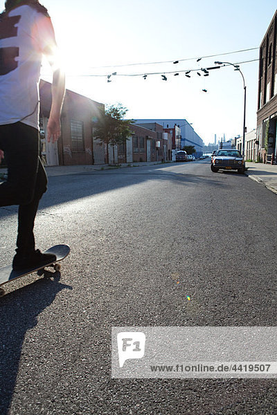 Skateboarder in städtischen Straße im Sonnenlicht