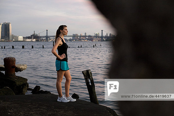 Runner standing by river in brooklyn