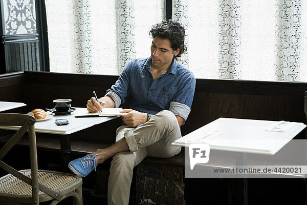 Man writing in coffee shop