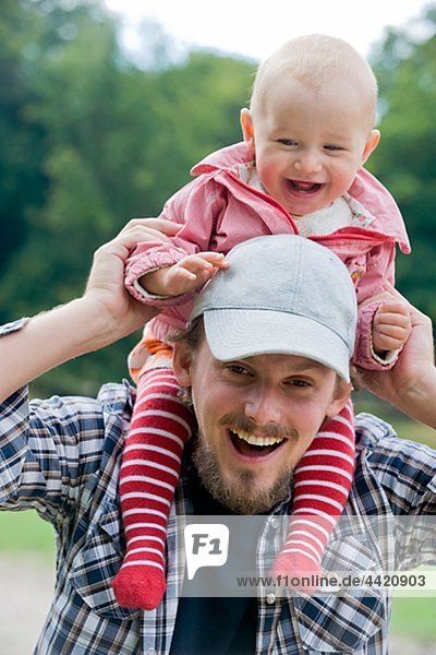 Father carrying baby on shoulder  laughing