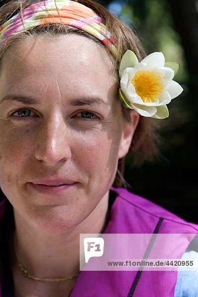 Frau trägt Blume im Haar  Lächeln  Nahaufnahme  portrait