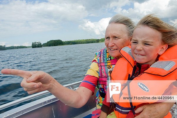 Grandmother and grandson riding in motorboat