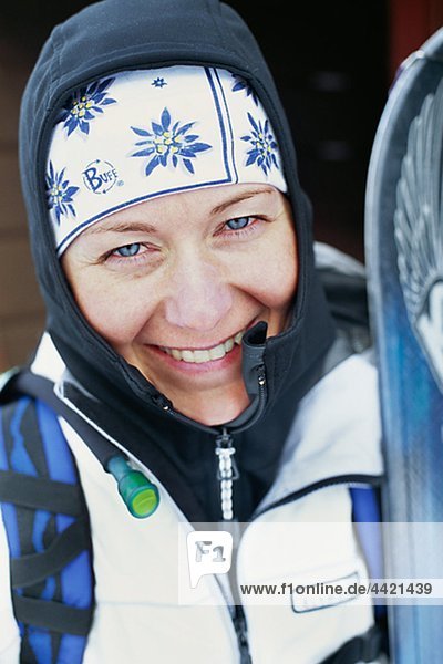 Porträt von lächelnd junge Frau hält ski