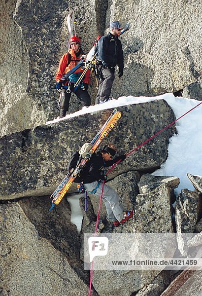 Telemark skiers climbing on rock