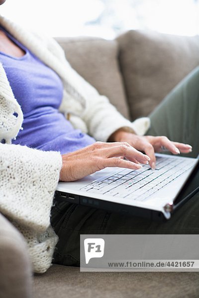 Frau sitzend auf Sofa und Surfen internet