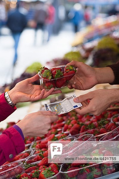 Woman paying for basket of strawberries