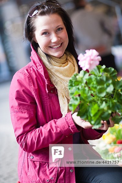Portrait of junge Frau hält Blumenstrauß