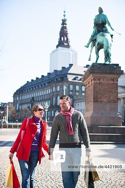 Paar mit Einkaufstaschen  zu Fuß in der Stadt