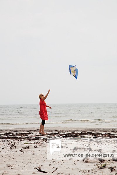 Frau flying Kite am Strand