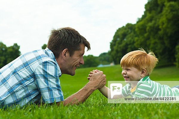 Boy and father arm wrestling