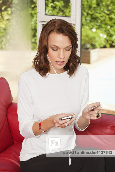 Young woman using iPhone  holding credit card