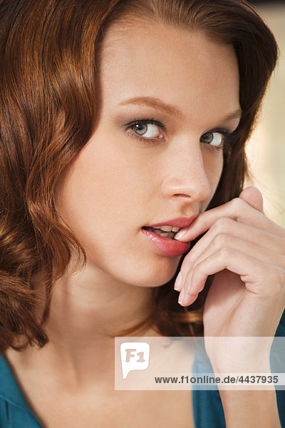 Young woman with finger in mouth
