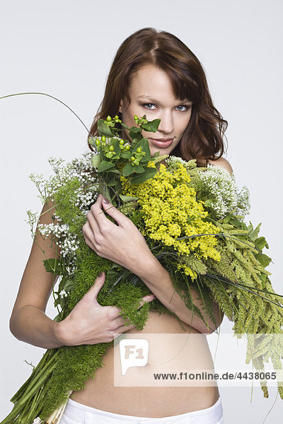 Junge Frau  die die Brust mit Blumen bedeckt