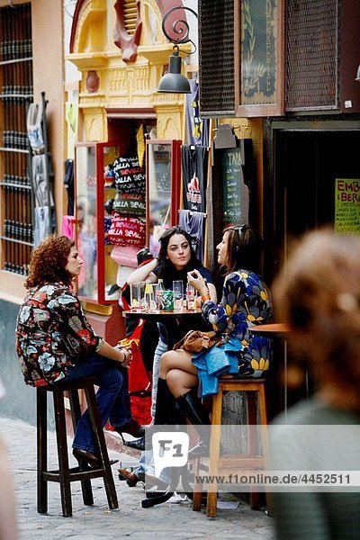 Three women sitting at a Bar Cafe in Barrio Santa Cruz Seville Spain.
