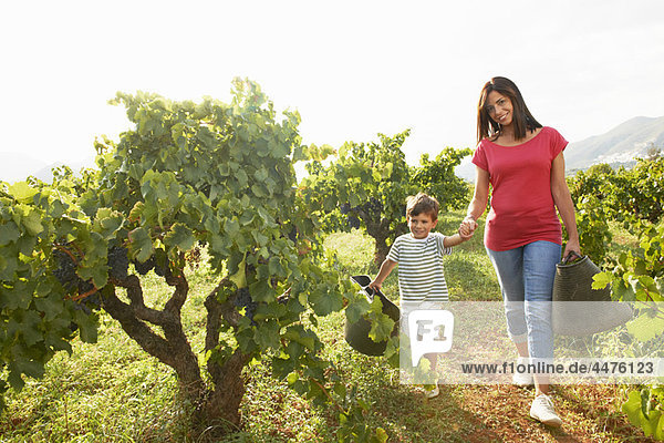 Mother and son walking in vineyard