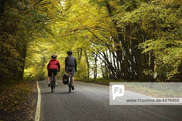 Couple cycling down country road