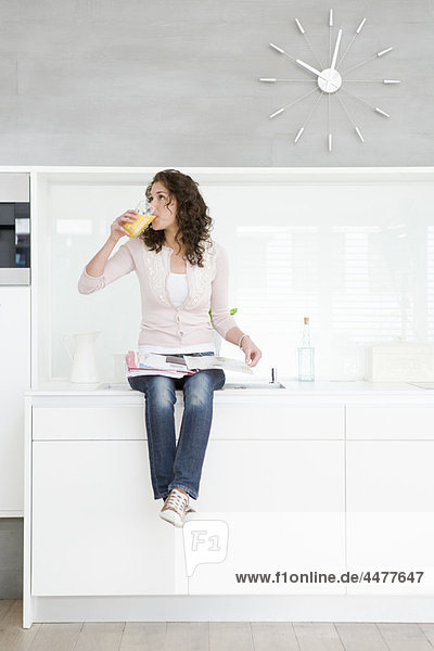 Frau auf Kochnische sitzend
