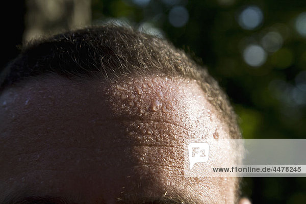 Ein Mann schwitzt  Detail der Stirn