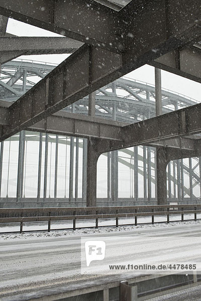 Die Metallkonstruktion einer Straßenbrücke im Schneesturm