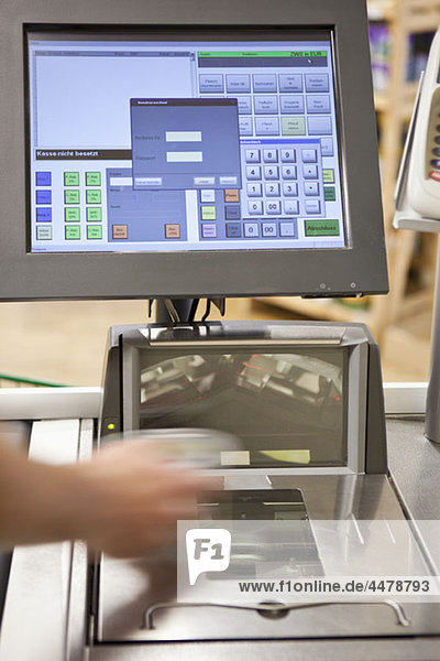 A cashier scanning groceries at a supermarket  focus on hand