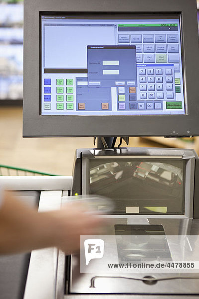 A cashier scanning groceries at a supermarket  focus on hand