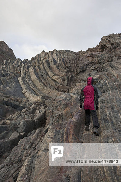 Rückansicht einer Frau beim Aufstieg auf einen felsigen Berg  Torres del Paine Nationalpark  Chile