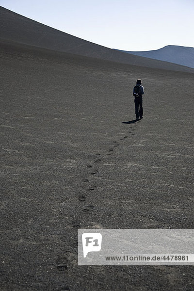 Rückansicht einer Frau  die über den Vulkan Lonquimay  Patagonien  Chile läuft.