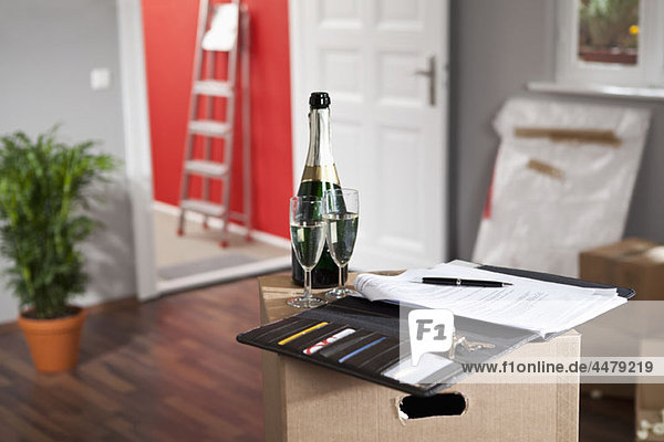 Champagne and a contract in a living room with moving boxes