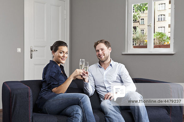 A couple toasting champagne flutes at home