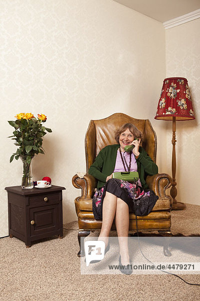 Eine ältere Frau zu Hause am Telefon