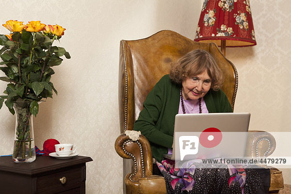 Eine ältere Frau mit einem Laptop