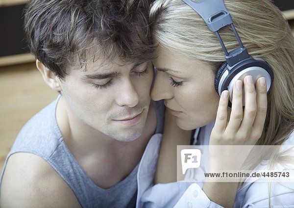 Young couple listening to music with headphones