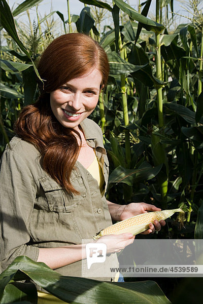 Young woman holding corn cob