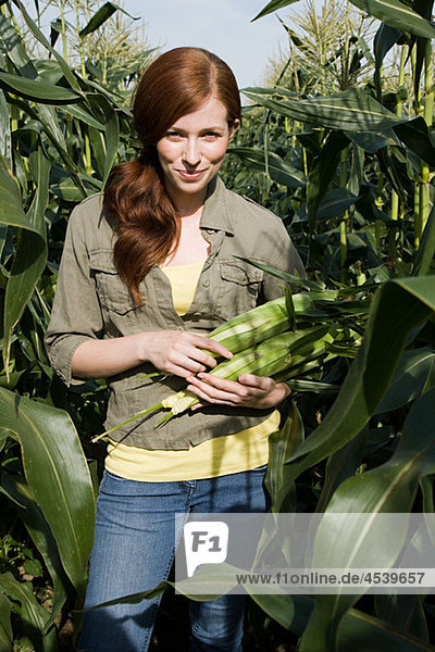 Young woman holding corn cob