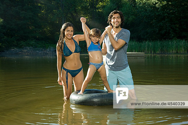 Paar und Tochter am See mit aufblasbaren ring