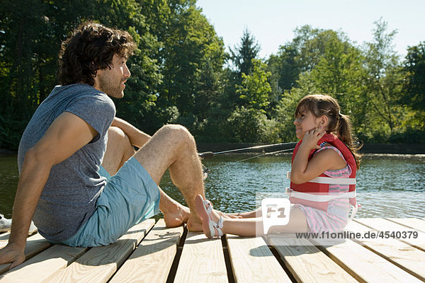 Vater und Tochter am Steg im See