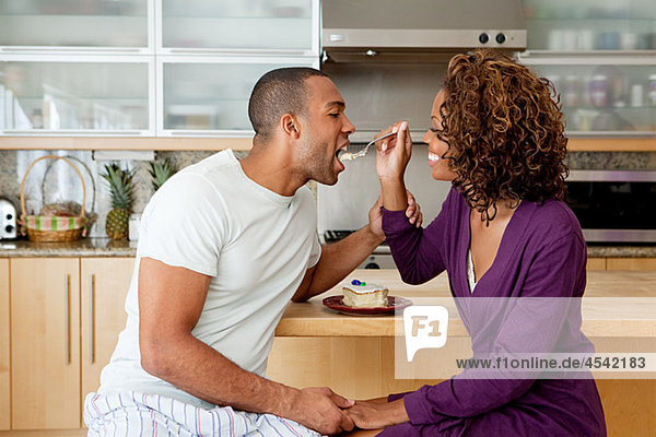 Woman feeding cake to boyfriend