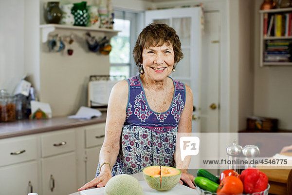 Senior woman in kitchen with fruit and vegetables