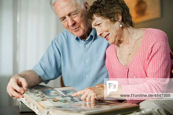 Seniorenpaar schaut sich Familienalbum an