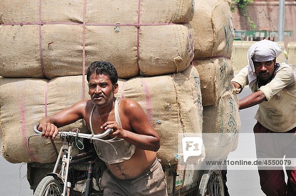 Two men carrying huge bags  Delhi India